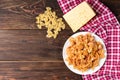 Pasta with chicken, spices and tomato sauce on dark wooden background