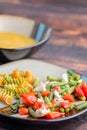 Pasta and chicken with vegetables on plate and pumpkin soup