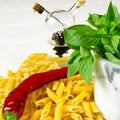 Pasta, chilli, green basil and olive oil on a white wood table Royalty Free Stock Photo