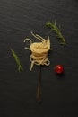 Pasta concept boiled long slim pasta curled with a form and placed on the black background