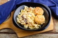 Pasta in a creamy sauce with mushrooms and chicken meatballs in a plate on a board on a blue napkin Royalty Free Stock Photo