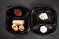 Pasta with cuttlefish ink and rolls of rice paper with vegetables in eco boxes. on a black background