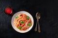 Pasta dish. Spaghetti with tomato sauce, Parmesan cheese and basil leaves, shot from above on a dark table Royalty Free Stock Photo