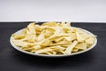 Pasta with durum wheat in a white plate on a black background. Side view. Royalty Free Stock Photo