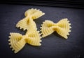 Pasta farfalla on a black basalt background. Three bows