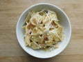 pasta farfalle with mushrooms, cheese and bacon in a white plate on a wooden table Royalty Free Stock Photo