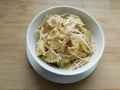 pasta farfalle with mushrooms, cheese and bacon in a white plate on a wooden table Royalty Free Stock Photo