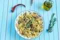 Pasta farfalle with turkey, pesto sauce and rosemary in serving plate over wooden turquoise background Royalty Free Stock Photo