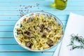 Pasta farfalle with turkey, pesto sauce and rosemary in serving plate over wooden turquoise background Royalty Free Stock Photo