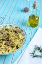 Pasta farfalle with turkey, pesto sauce and rosemary in serving plate over wooden turquoise background