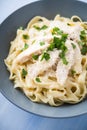 Pasta fettuccine alfredo with chicken, parmesan and parsley on blue wood background close up Royalty Free Stock Photo