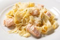 Pasta fettuccine alfredo with chicken, parmesan and parsley on white plate. Italian cuisine.