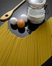 Pasta, flour container, eggs and spoon