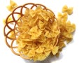 Pasta in the form o# bows in a basket on a white background. Royalty Free Stock Photo