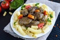 Pasta and fried goose liver (chicken, duck) with pesto and tomato on a black background Royalty Free Stock Photo