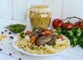 Pasta and fried goose liver (chicken, duck) with pesto and tomato on a white background Royalty Free Stock Photo