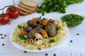 Pasta and fried goose liver (chicken, duck) with pesto and tomato on a white background Royalty Free Stock Photo