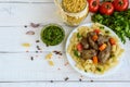 Pasta and fried goose liver (chicken, duck) with pesto and tomato on a white background. Royalty Free Stock Photo