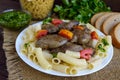 Pasta and fried goose liver (chicken, duck) with pesto and tomato on a wooden background Royalty Free Stock Photo