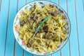 Pasta with grilled turkey, pesto sauce and rosemary in serving plate over wooden turquoise background Royalty Free Stock Photo