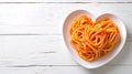 Pasta in heart shaped plate on wooden table with copy space. cooked spaghetti with tomatoes Royalty Free Stock Photo