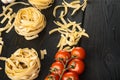 Pasta ingredients Tagliatelle with Italian food ingredients, on black wooden table background, with copy space for text Royalty Free Stock Photo