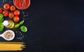 Pasta ingredients - tomatoes, olive oil, garlic, italian herbs, fresh basil, salt and spaghetti on a black stone background Royalty Free Stock Photo