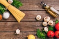 Pasta ingredients - tomatoes, olive oil, garlic, italian herbs, fresh basil, salt and spaghetti on a wooden background Royalty Free Stock Photo