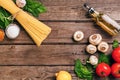 Pasta ingredients - tomatoes, olive oil, garlic, italian herbs, fresh basil, salt and spaghetti on a wooden background Royalty Free Stock Photo