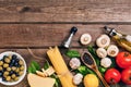 Pasta ingredients - tomatoes, olive oil, garlic, italian herbs, fresh basil, salt and spaghetti on a wooden background Royalty Free Stock Photo