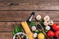 Pasta ingredients - tomatoes, olive oil, garlic, italian herbs, fresh basil, salt and spaghetti on a wooden background Royalty Free Stock Photo