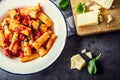 Pasta. Italian and Mediterrannean cuisine. Pasta Rigatoni with tomato sauce basil leaves garlic and parmesan cheese.