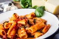 Pasta. Italian and Mediterrannean cuisine. Pasta Rigatoni with tomato sauce basil leaves garlic and parmesan cheese. Royalty Free Stock Photo