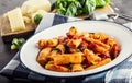 Pasta. Italian and Mediterrannean cuisine. Pasta Rigatoni with tomato sauce basil leaves garlic and parmesan cheese. Royalty Free Stock Photo