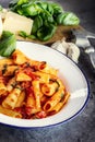 Pasta. Italian and Mediterrannean cuisine. Pasta Rigatoni with tomato sauce basil leaves garlic and parmesan cheese. Royalty Free Stock Photo