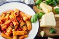 Pasta. Italian and Mediterrannean cuisine. Pasta Rigatoni with tomato sauce basil leaves garlic and parmesan cheese. Royalty Free Stock Photo