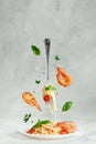 Pasta linguine with prawns and fork flying over the dish. Creative still life. Italian food. Royalty Free Stock Photo