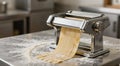 Pasta machine extruding fresh pasta on floured counter Royalty Free Stock Photo