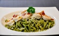Pasta made from spinach in green color and spicy sauce with Shirmps