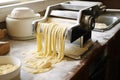 pasta maker machine with a batch of fresh tagliatelle noodles Royalty Free Stock Photo