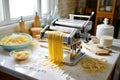 pasta maker machine with a batch of fresh tagliatelle noodles Royalty Free Stock Photo