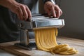 Pasta maker rolls fresh egg dough through manual machine with smooth repetition Royalty Free Stock Photo