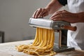 Pasta maker rolls fresh egg dough through manual machine with smooth repetition Royalty Free Stock Photo
