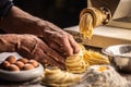 Pasta making machine and fresh spaghetti or fettuccine pasta shaped into nests