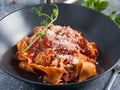Pasta with meatballs in tomato sauce in a dark dish Royalty Free Stock Photo