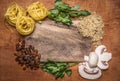 Pasta nest herbs chopped walnuts raisins, mushrooms on a cutting board rustic wooden background top view