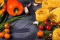 Pasta nests capellini, vegetables and herbs framing copy space on the grey table Royalty Free Stock Photo