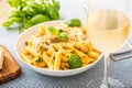 Pasta penne with chicken pieces mushrooms basil parmesan cheese and white wine. Italian food in white plate on kitchen Royalty Free Stock Photo