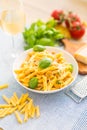 Pasta penne with chicken pieces mushrooms basil parmesan cheese and white wine. Italian food in white plate on kitchen Royalty Free Stock Photo