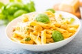 Pasta penne with chicken pieces mushrooms basil parmesan cheese and white wine. Italian food in white plate on kitchen Royalty Free Stock Photo